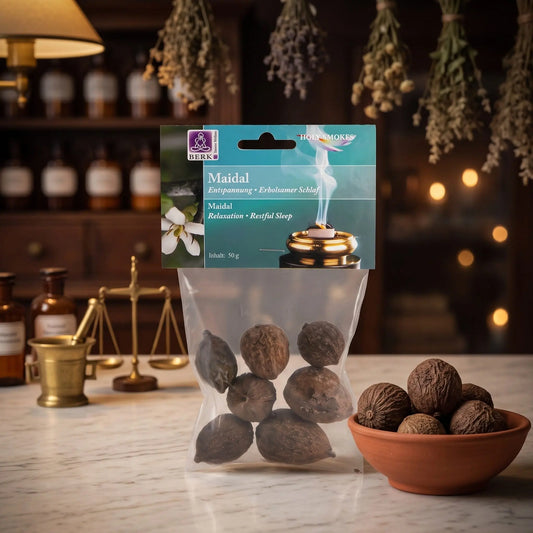 Maidal-Nüsse (Traumnüsse), sortenreines Räucherwerk von Berk, 50 g: Packung auf der Marmortheke einer alten Apotheke am Abend, daneben eine Terracottaschale mit ganzen Maidal-Nüssen – Spirit of Gaia