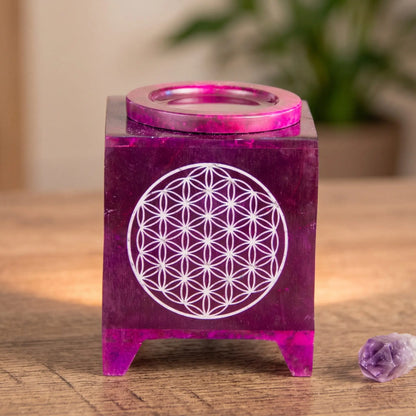 Aromalampe Blume des Lebens: auf einem Holz-Sideboard im Wohnzimmer am Abend, daneben ein Amethyst