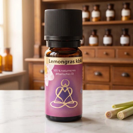 Ätherisches Öl Lemongras: Fläschchen aus Braunglas auf Marmortheke vor Apothekerschrank, daneben Zitronengras – Spirit of Gaia