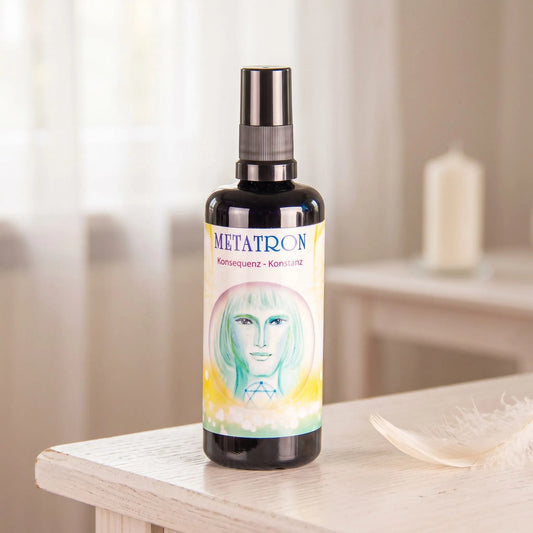 Seraphim Engel-Essenz Metatron: Sprühflasche auf einem weißen Beistelltisch in einem hellen Raum, daneben eine weiße Feder