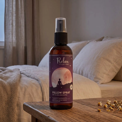Kissenspray Relax auf dem Nachttisch im Schlafzimmer am Abend, dahinter Bett mit Leinenkissen