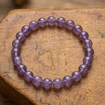 Makro der naturbelassenen, halbtransluzenten Amethyst-Perlen des Edelstein-Kugelarmbands