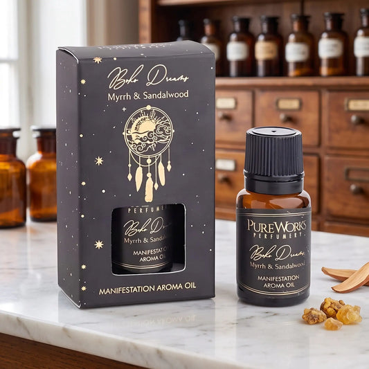 Aromaöl Boho Dreams (Myrrhe & Sandelholz) von Pure Works: Fläschchen und schwarze Schachtel mit Goldprägung auf Marmortheke vor Apothekerschrank, daneben Myrrheharz und Sandelholzspäne – Spirit of Gaia