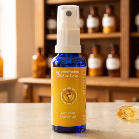 Ayurvedisches Chakra-Spray Manipura (Solarplexus-Chakra): 30-ml-Sprühflasche aus blauem Glas auf Marmortheke vor Apothekerschrank, daneben Citrin – Spirit of Gaia