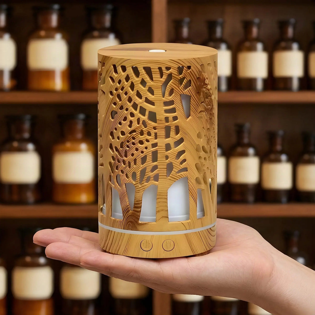 Hand hält den 15,7 cm hohen, schlanken Aroma Diffuser Zen Forest vor einem Apothekerregal