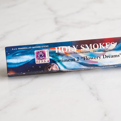 Nahaufnahme der Packung Flowering Dreams Sortiment 2 mit Holy-Smokes-Schriftzug, Berk-Esoterik-Logo und dem Aufdruck 9 x 2 Räucherstäbchen auf Marmor