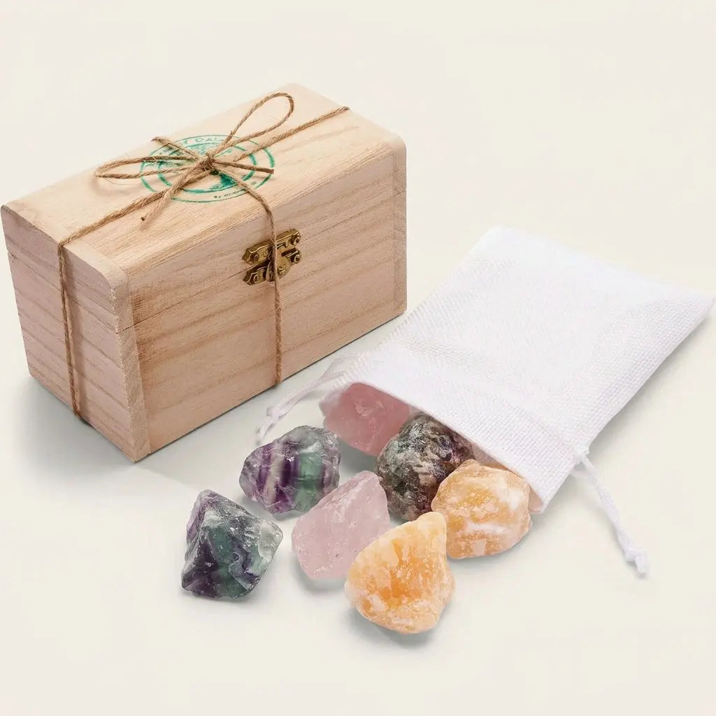 Wassersteine Guter Schlaf – Holzkästchen mit weißem Jutesäckchen und Rohsteinen Regenbogenfluorit, Rosenquarz und Orangencalcit vor hellem Hintergrund – Spirit of Gaia