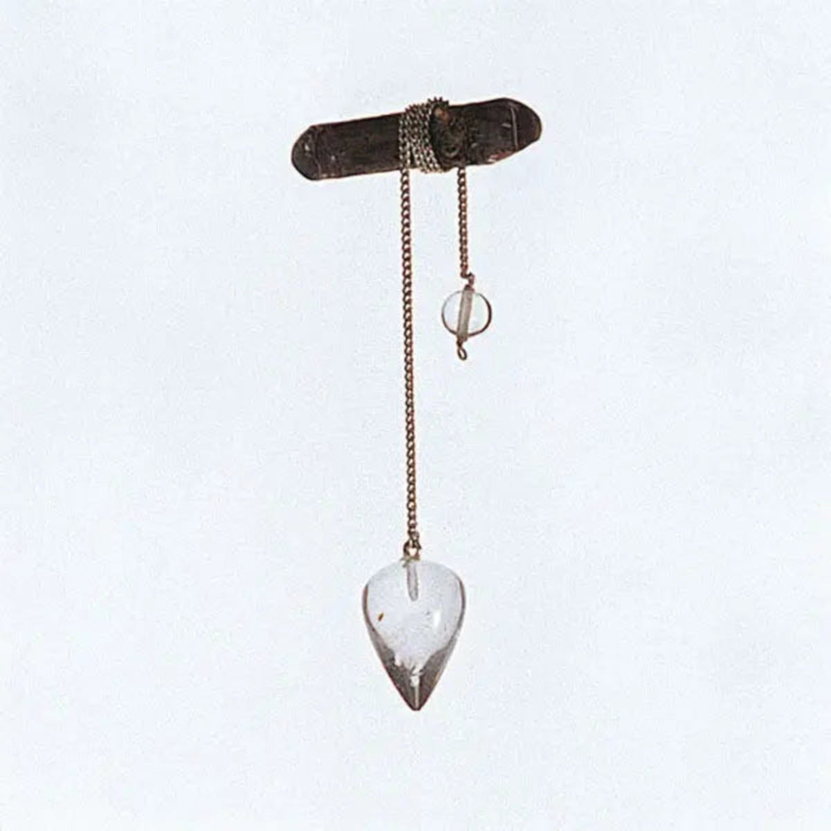 Bergkristall-Pendel mit Edelstahl-Panzerkette, Tropfen ca. 2,5 cm: hängend an einem Zweig vor hellem Grund
