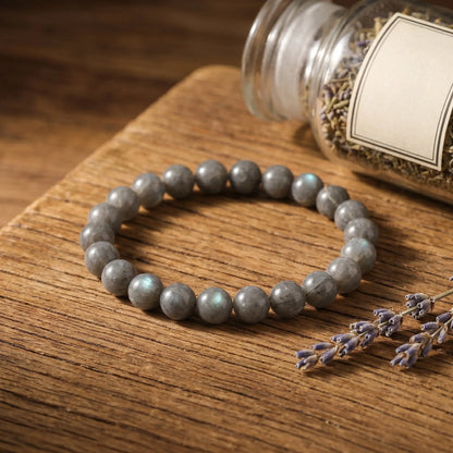 Labradorit Kugelarmband auf warmem Holz mit getrocknetem Lavendel im Apotheker-Look