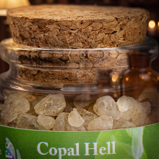 Copal Hell, reines Räucherharz von Berk, 60 ml im Korkglas: Nahaufnahme des Glases mit hellem Copal, Korken und Etikett vor der warmen, unscharfen Abendapotheke – Spirit of Gaia