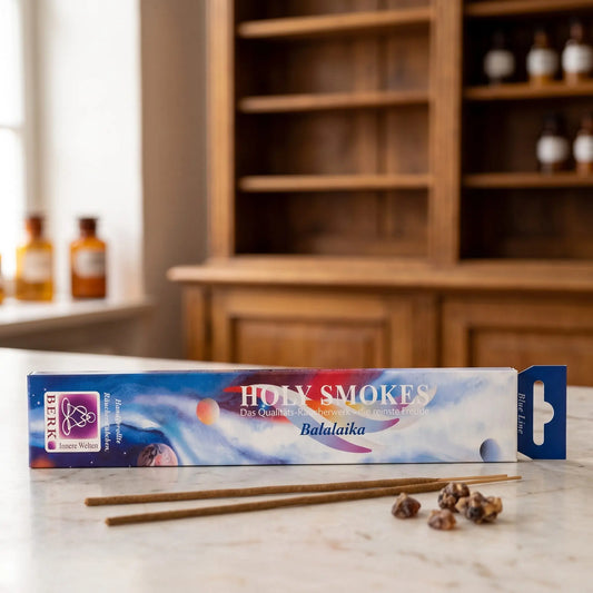 Balalaika Räucherstäbchen Blue Line: Packung auf einer Marmortheke vor einem Apothekerschrank, daneben zwei lose Räucherstäbchen und ein paar Stücke Benzoeharz – Spirit of Gaia