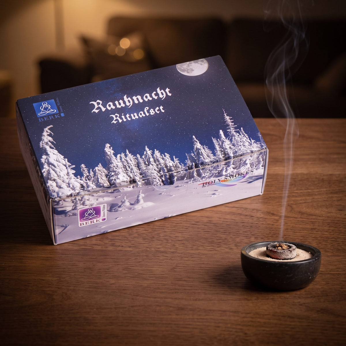 Rauhnacht Ritualset von Berk: glimmende Räucherkohle in einer kleinen Specksteinschale vor der großen Geschenkbox, feiner Rauch steigt am Abend auf – Spirit of Gaia