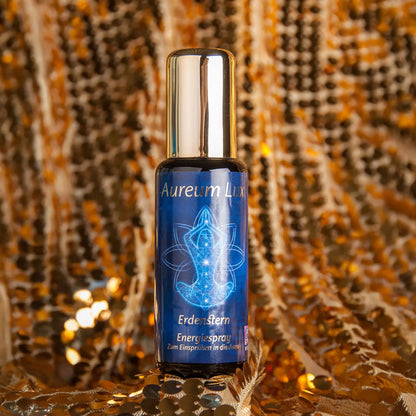 Energiespray Aureum Lux Erdenstern, 50-ml-Sprühflasche aus Violettglas vor glitzerndem Hintergrund
