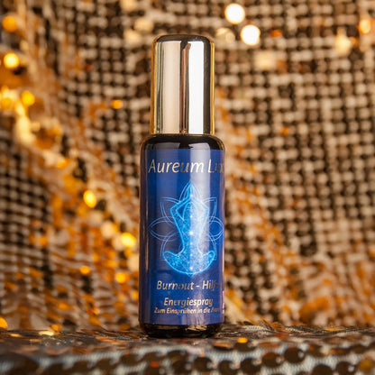 Energiespray Aureum Lux Burnout-Hilfe, 50-ml-Sprühflasche aus Violettglas vor glitzerndem Hintergrund