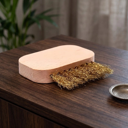 Bürste zur Reinigung der Räuchergefäss-Siebe auf einem dunklen Holz-Sideboard im Wohnzimmer