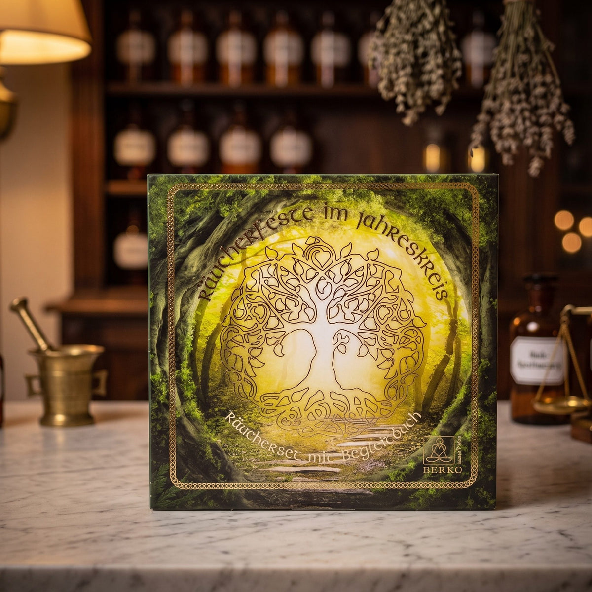 Räucherset Jahreskreisfeste von Berk: die Geschenkbox mit goldenem keltischem Lebensbaum auf der Marmortheke einer alten Apotheke am Abend – Spirit of Gaia