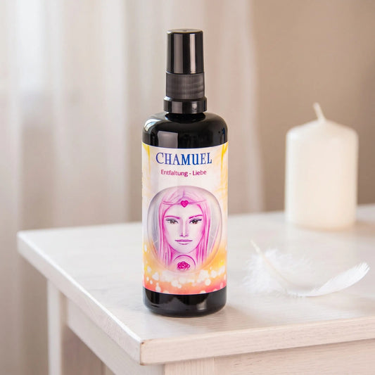 Seraphim Engel-Essenz Chamuel: Sprühflasche auf einem weißen Beistelltisch in einem hellen Raum, daneben eine weiße Feder