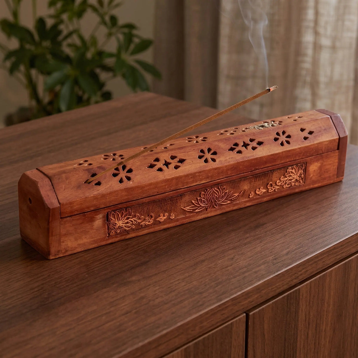 Kistchen/Halter für Räucherstäbchen Lotus: glimmendes Räucherstäbchen mit feinem Rauch über dem geschlossenen Kistchen, auf einem Sideboard am Abend