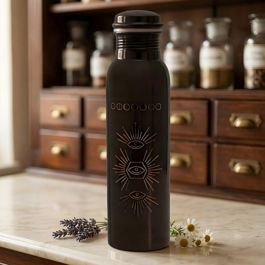 Antik-dunkle Kupfer-Trinkflasche mit gravierter Sonne auf Marmortheke vor Apothekerschrank – Spirit of Gaia