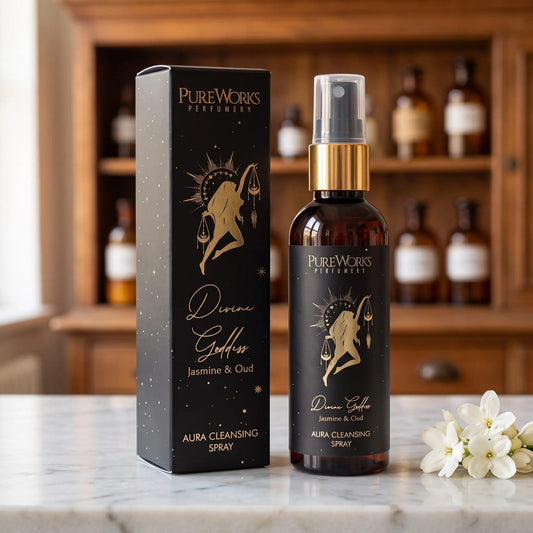 Aura-Spray Divine Goddess (Jasmin & Oud) von Pure Works: Sprühflasche mit Goldkragen und schwarze Schachtel auf Marmortheke vor Apothekerschrank – Spirit of Gaia