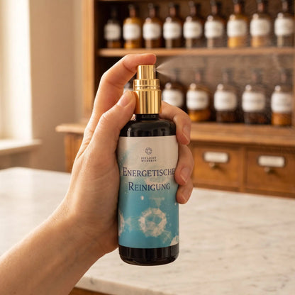 Hand sprüht einen feinen Nebel aus dem Aura Spray Energetische Reinigung in den Raum