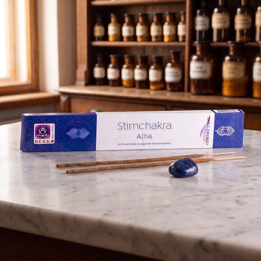 Stirnchakra Räucherstäbchen Holy Smokes: Packung auf einer Marmortheke vor einem Apothekerschrank, daneben zwei lose Räucherstäbchen und ein Trommelstein – Spirit of Gaia