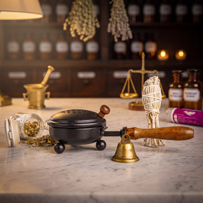 Set Energetische Hausreinigung von Berk, Inhalt: Eisenpfanne mit Holzstiel, Bündel weißer Salbei, Räuchermischung Hausreinigung im Bügelglas, Glöckchen und Kohletabletten auf der Marmortheke – Spirit of Gaia