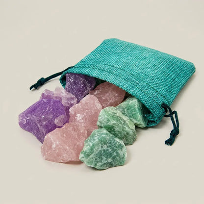 Wassersteine Entspannung im türkisen Jutesäckchen mit Amethyst, Rosenquarz und Aventurin vor hellem Hintergrund – Spirit of Gaia