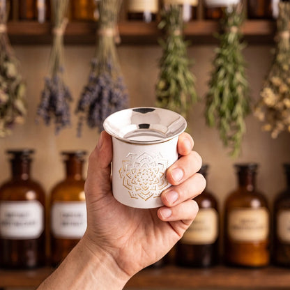Weißes Räucherstövchen aus Eisen mit erhabenem Mandala und flacher Edelstahlschale – Groessenvergleich in der Hand
