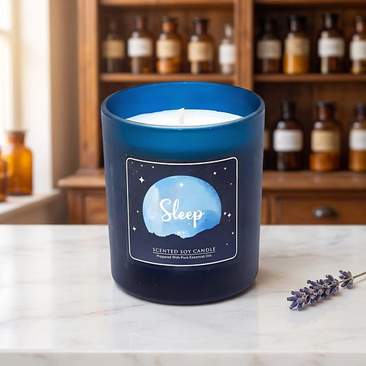 Duftkerze Sleep im Glas von Song of India: Sojawachskerze im dunkelblauen Glas auf Marmortheke vor Apothekerschrank, daneben ein Lavendelzweig – Spirit of Gaia