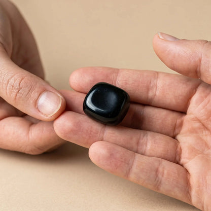 Onyx Trommelstein – Größenvergleich in der Hand, ca. 2–3 cm