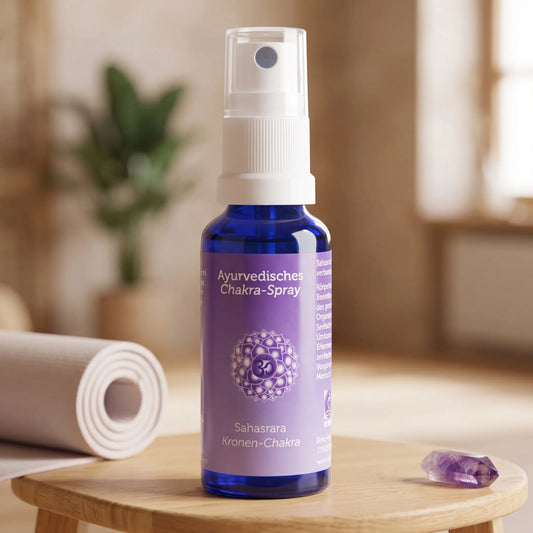 Ayurvedisches Chakra-Spray Sahasrara (Kronen-Chakra): 30-ml-Sprühflasche auf einem Holzhocker neben einer gerollten Yogamatte, daneben Amethyst