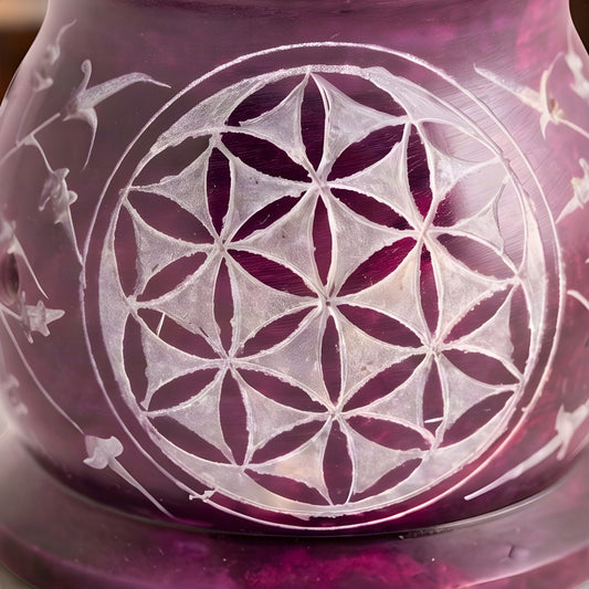 Nahaufnahme der in den violetten Speckstein geritzten Blume des Lebens im hellen Kreis