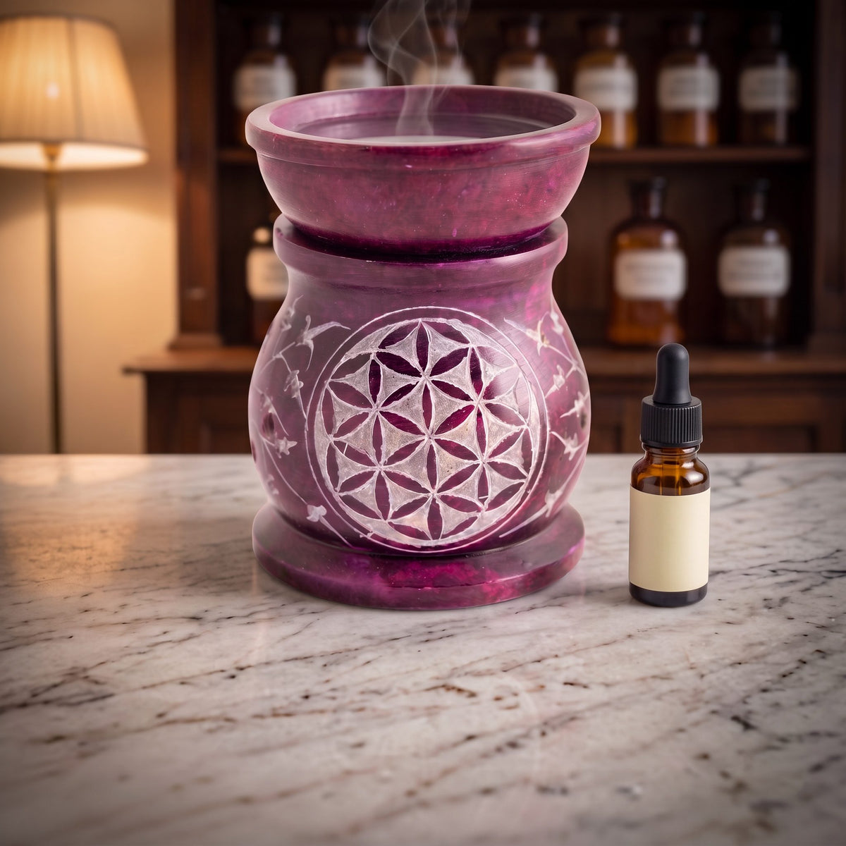 Aromalampe Blume des Lebens mit Wasser in der Schale, feinem Dampf und einem Tropfenfläschchen daneben
