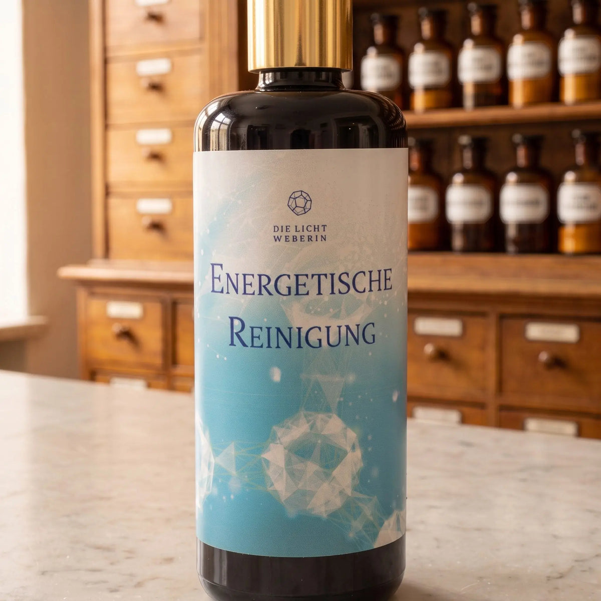 Etikett des Aura Sprays Energetische Reinigung aus der Nähe: Dodekaeder-Zeichen, Schriftzug Die Lichtweberin, Violettglas mit goldenem Pumpkragen