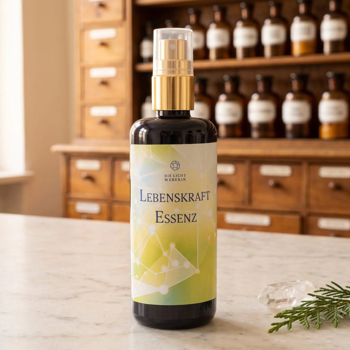 Aura Spray Lebenskraft der Lichtweberin: Flasche aus Violettglas mit goldener Pumpe auf einer Marmortheke vor einem Apothekerschrank