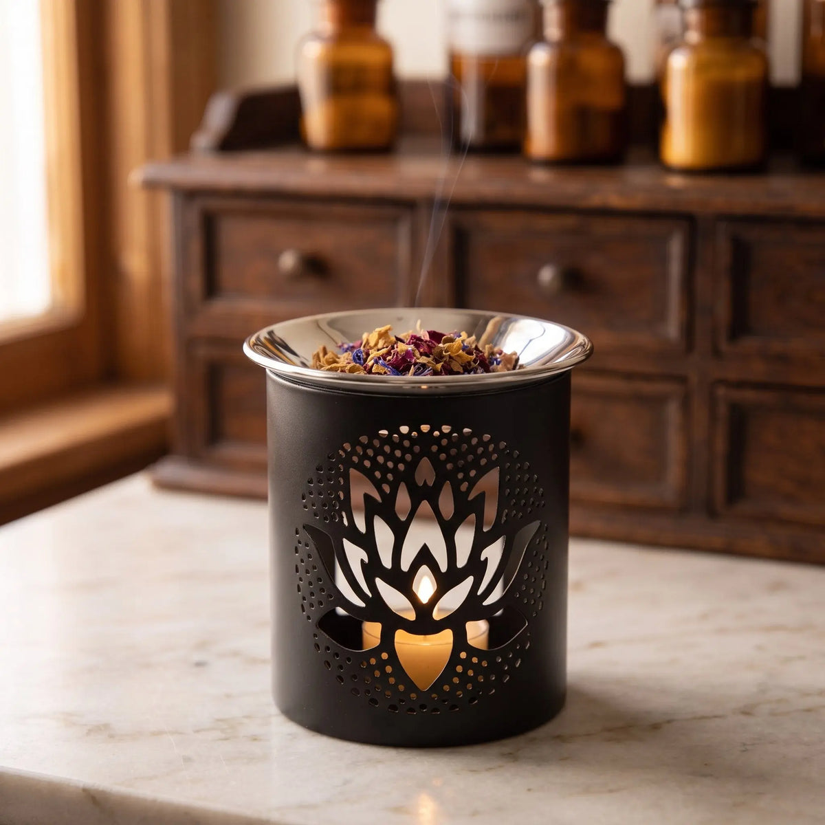 Schwarzes Räuchergefäß aus Eisen mit ausgestanztem Lotus und flacher Edelstahlschale – in der Anwendung