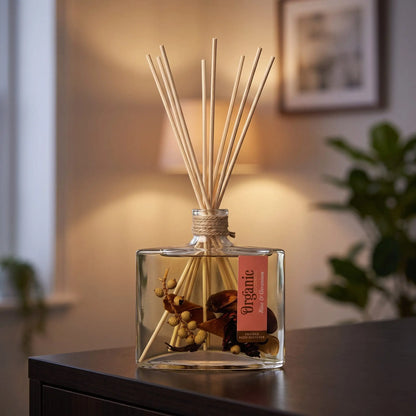 Reed Diffuser Rose und Geranie am Abend auf einem Sideboard, die Schilfrohrstäbchen aufgefächert