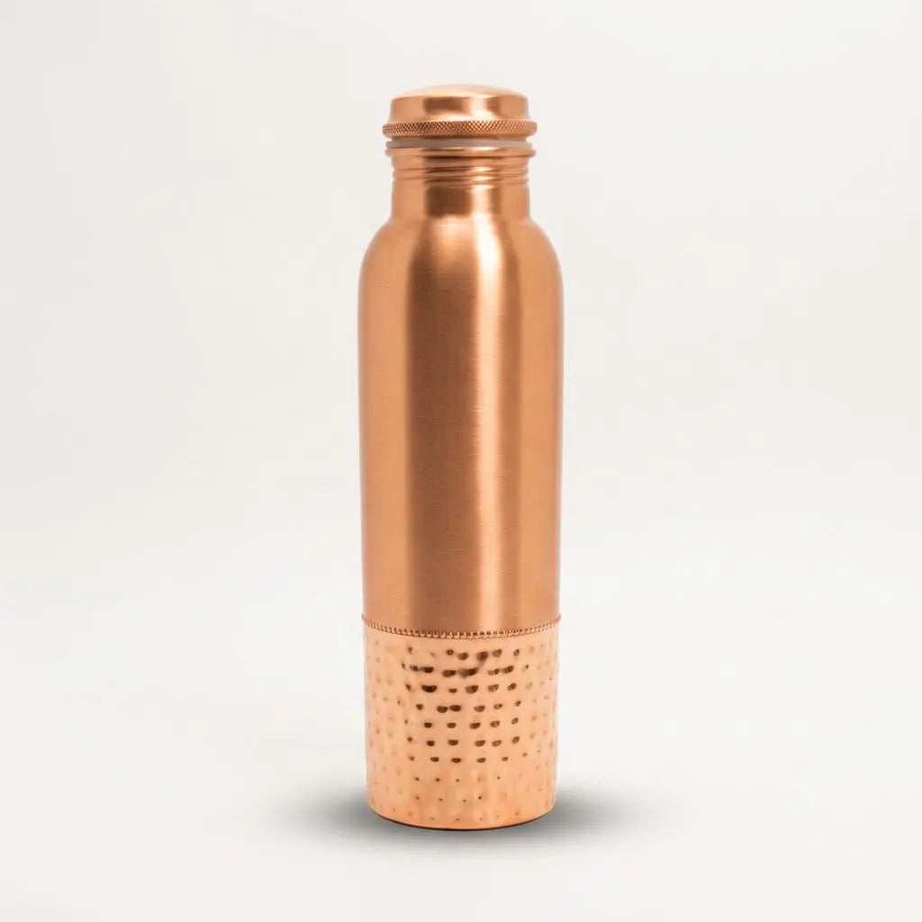 Kupfer-Trinkflasche mit gehämmertem Sockel freigestellt auf hellem Hintergrund mit weichem Schatten