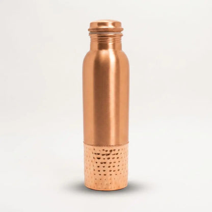 Kupfer-Trinkflasche mit gehämmertem Sockel freigestellt auf hellem Hintergrund mit weichem Schatten