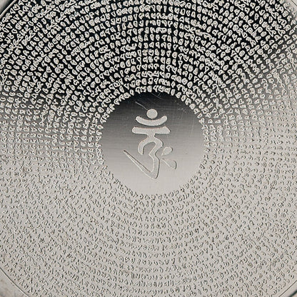 Nahaufnahme des OM im glatten Mittelfeld und der Mantra-Gravur in feinen Kreisen auf silberfarbenem Edelstahl