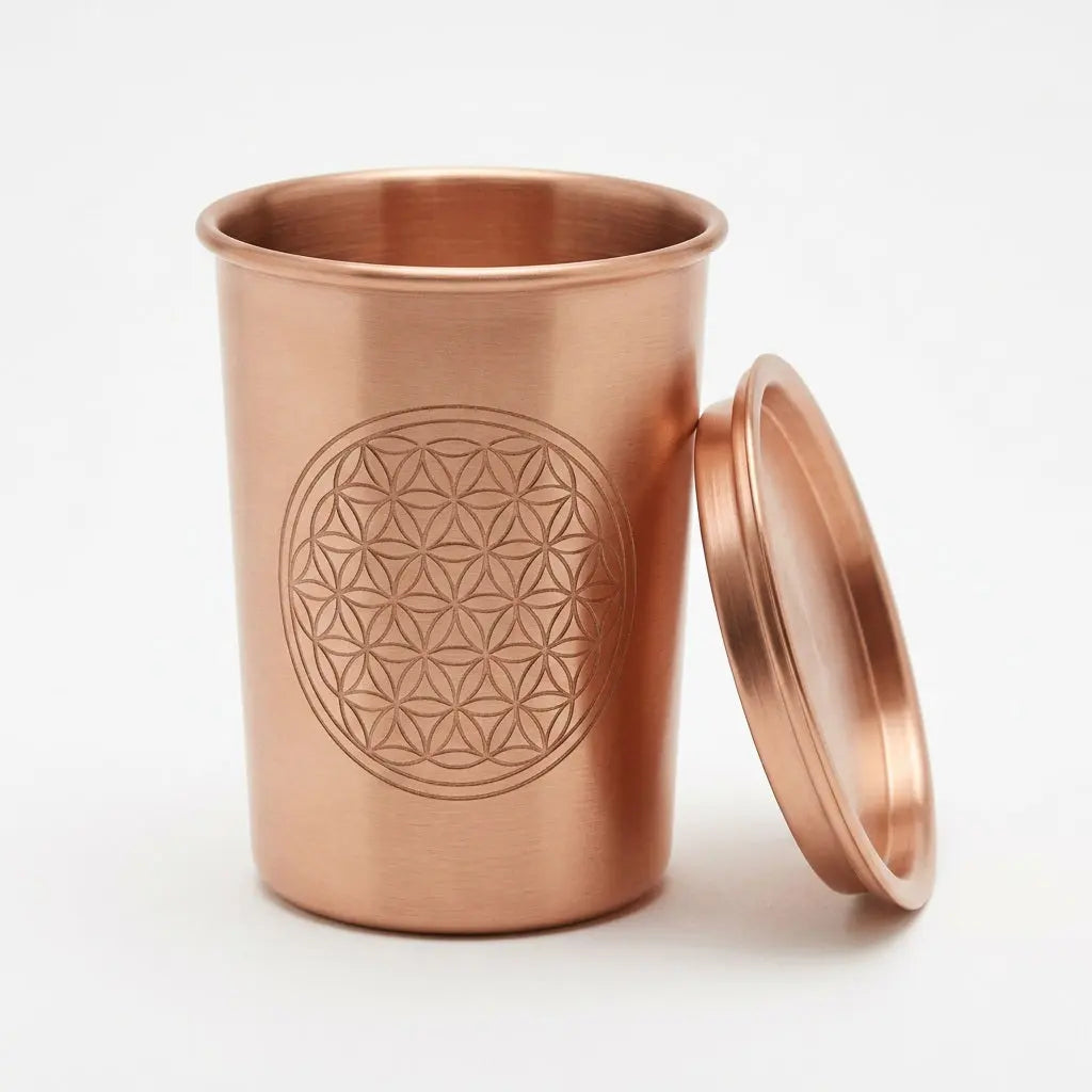 Kupferbecher Flower of Life mit Deckel daneben, freigestellt auf hellem Hintergrund