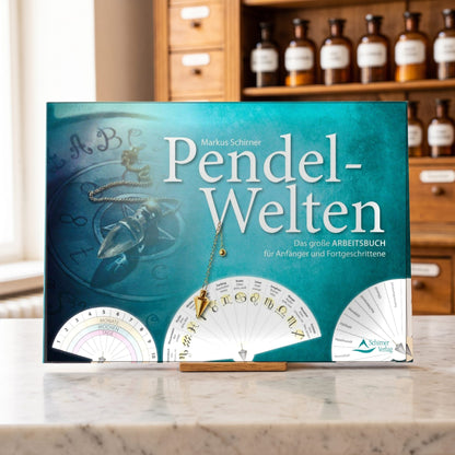 Buch Pendel-Welten von Markus Schirner im Querformat steht auf der Marmortheke einer hellen Apotheke