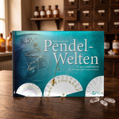 Buch Pendel-Welten liegt auf einem dunklen Holztisch, daneben drei kleine Bergkristalle