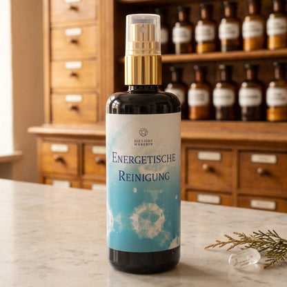 Aura Spray Energetische Reinigung der Lichtweberin: Flasche aus Violettglas mit goldener Pumpe auf einer Marmortheke vor einem Apothekerschrank