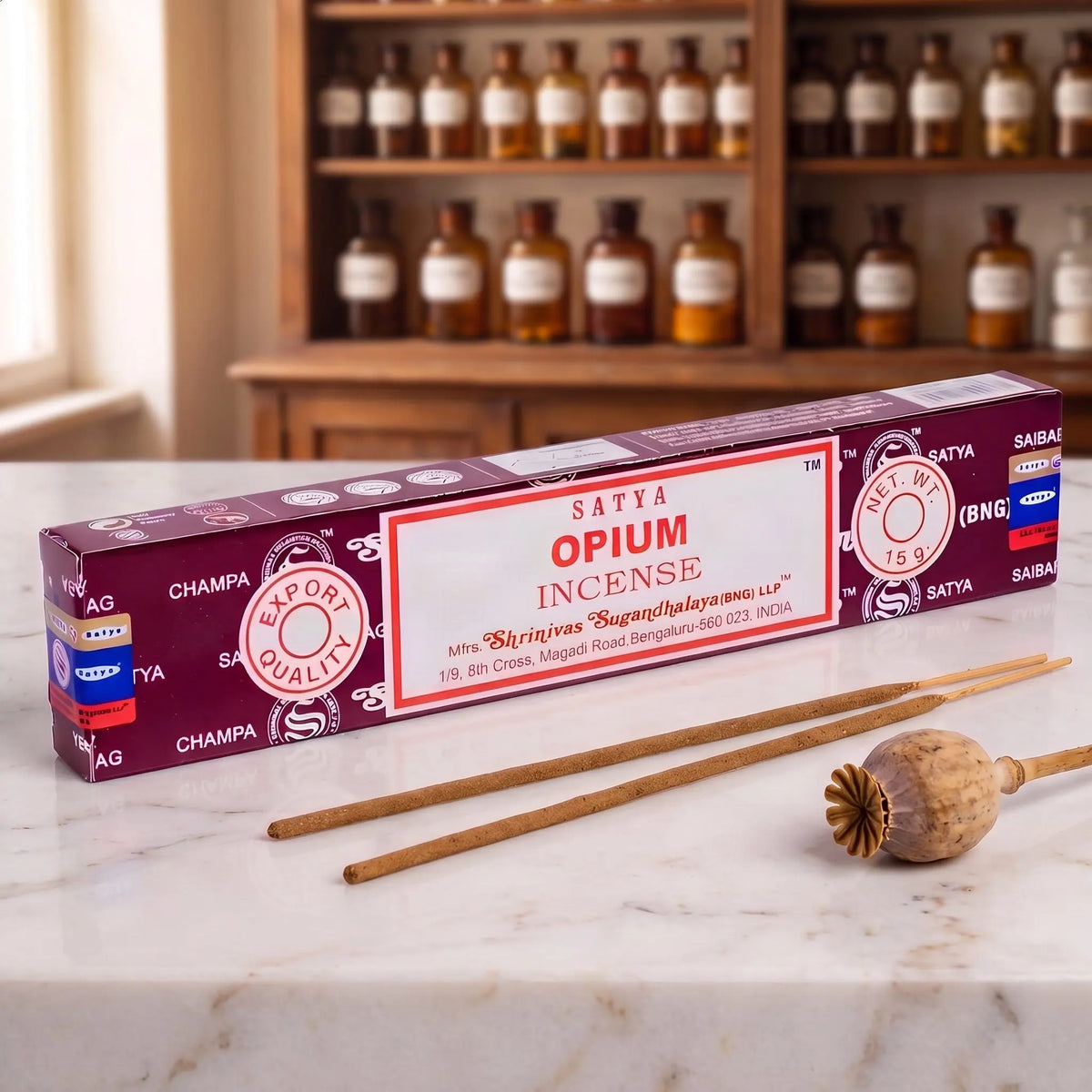 Satya Opium Räucherstäbchen: 15-g-Packung auf einer Marmortheke vor einem Apothekerschrank, daneben zwei lose Räucherstäbchen – Spirit of Gaia