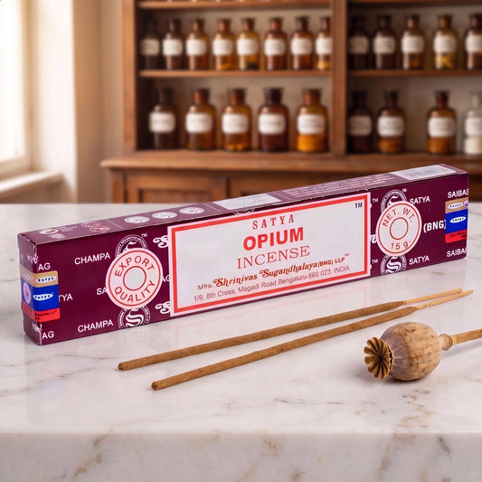 Satya Opium Räucherstäbchen: 15-g-Packung auf einer Marmortheke vor einem Apothekerschrank, daneben zwei lose Räucherstäbchen – Spirit of Gaia