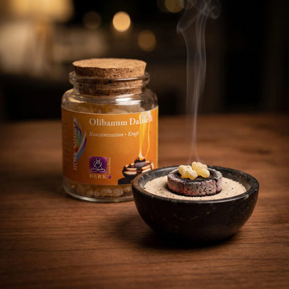 Olibanum Dalzielli, reiner Weihrauch von Berk, 60 ml im Korkglas: zwei Weihrauchtränen glimmen auf der Räucherkohle, dahinter das Korkglas, feiner Rauch steigt auf einer dunklen Holzplatte am Abend auf – Spirit of Gaia