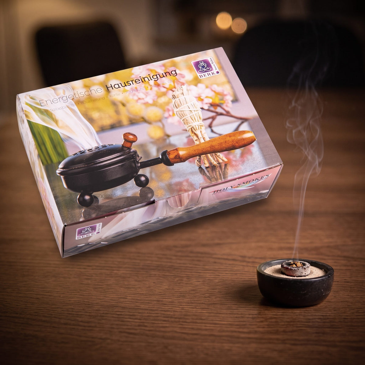 Set Energetische Hausreinigung von Berk: glimmende Räucherkohle in einer kleinen Specksteinschale vor der großen Geschenkbox, feiner Rauch steigt am Abend auf – Spirit of Gaia