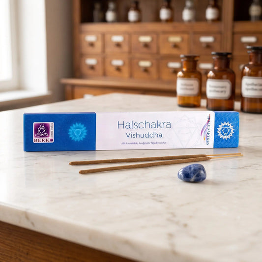 Halschakra Räucherstäbchen Holy Smokes: Packung auf einer Marmortheke vor einem Apothekerschrank, daneben zwei lose Räucherstäbchen und ein Trommelstein – Spirit of Gaia